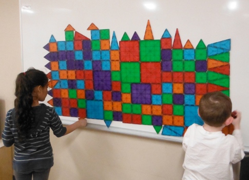 children building with mosaic tiles on a whiteboard