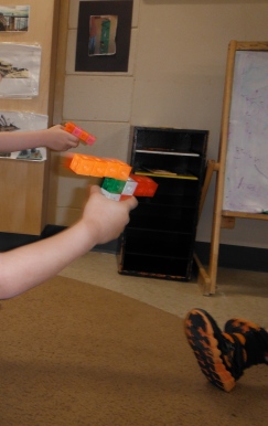 children's hands holding snap cube guns